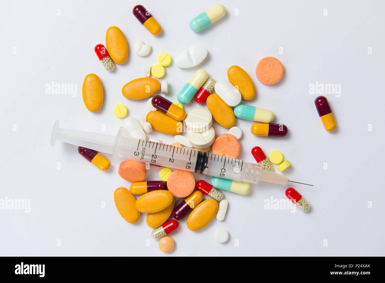 Pila di varie pillole colorate isolato su bianco Foto Stock