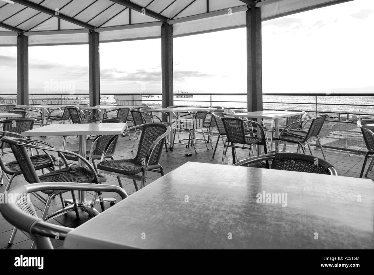 Le sedie e i tavoli in un bar sulla spiaggia con vista al mare, architettura sulla spiaggia di Lignano Foto Stock