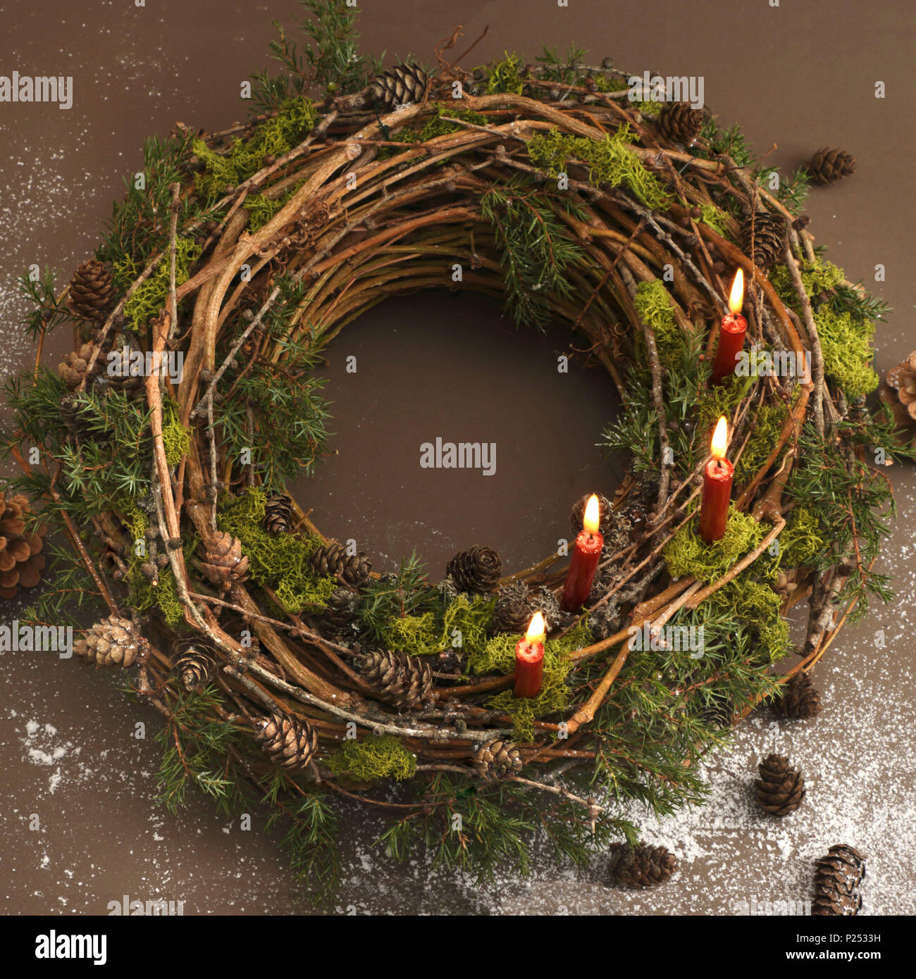 Pre-Christmassy ornato ghirlanda di vite con candele accese Foto Stock
