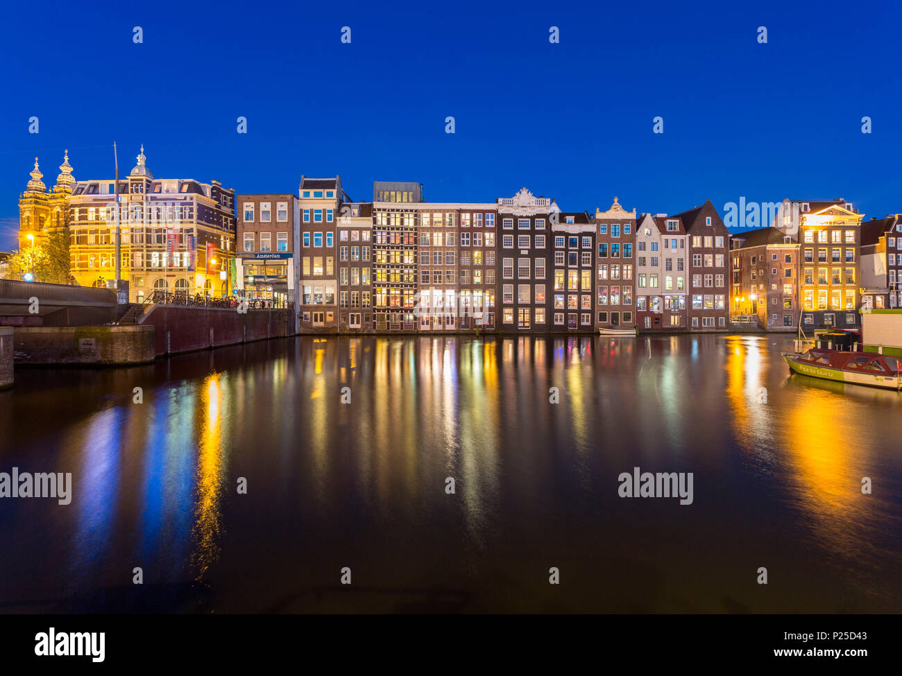 Amsterdam, Paesi Bassi. Paesaggio urbano con luci di posizione accese, riflettendo su un canale in una notte Foto Stock