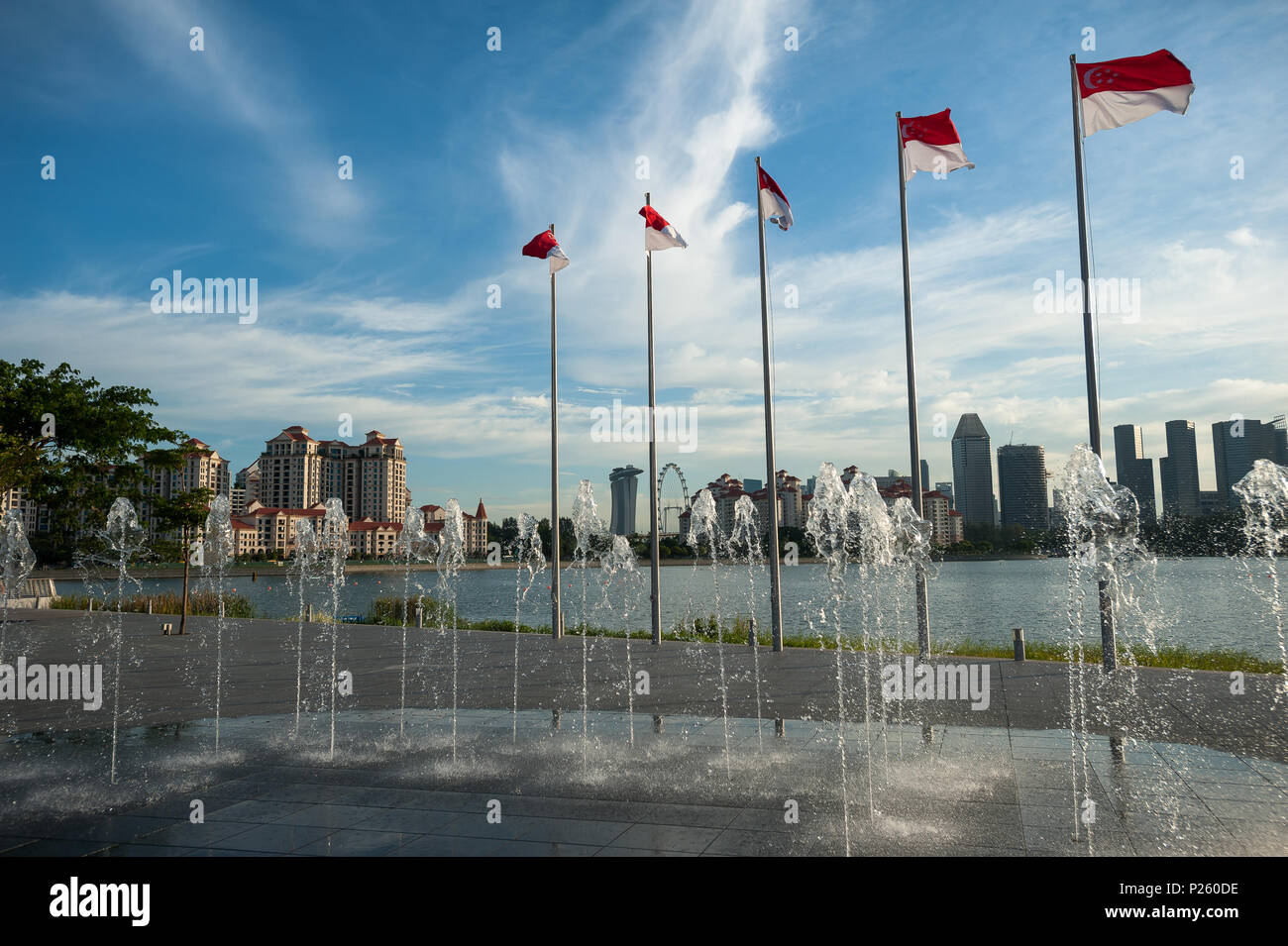 Singapore, Singapore, bandiere e gioco d'acqua sulla riva del fiume Foto Stock