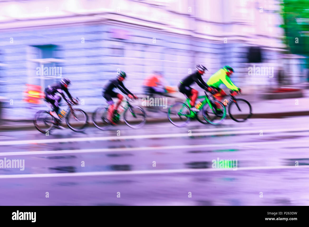 Abstract sport sfocato sfondo viola con luminosi colorati i ciclisti sulla strada di città Foto Stock