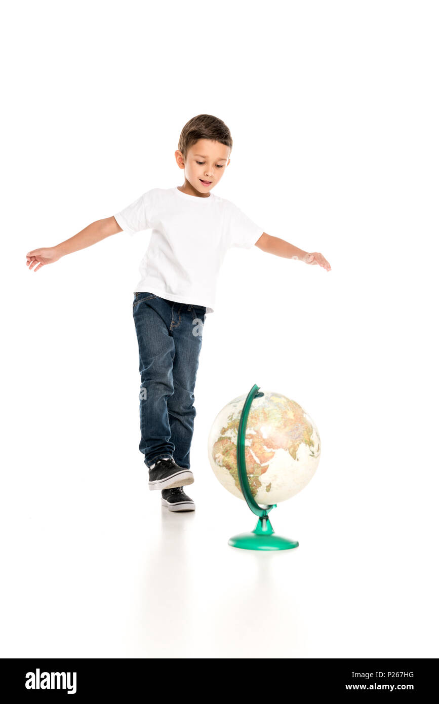 Caucasian little boy in piedi vicino a globe isolato su bianco Foto Stock