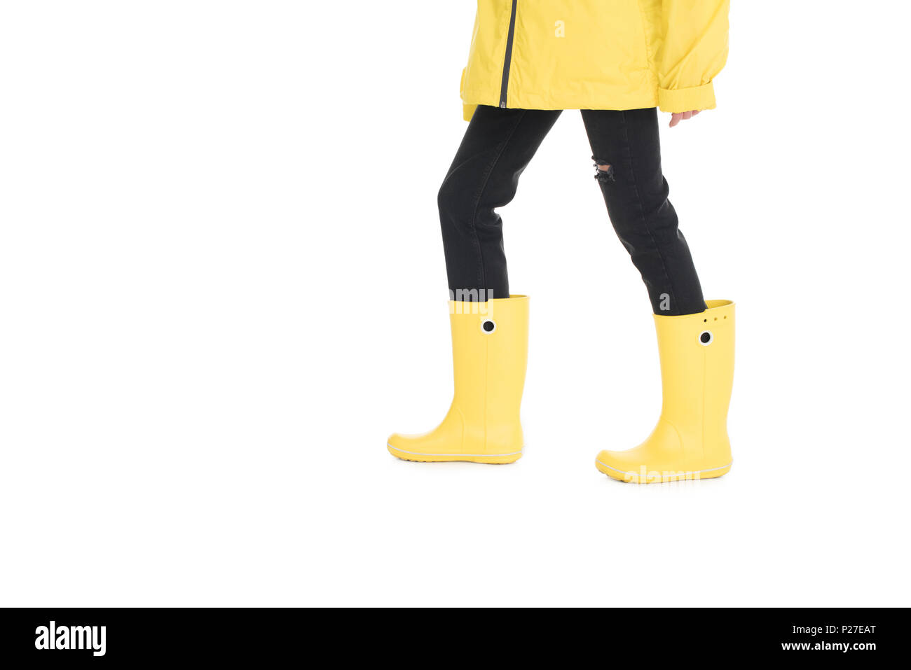 Vista parziale di donna in giallo impermeabile e stivali da pioggia isolato su bianco Foto Stock