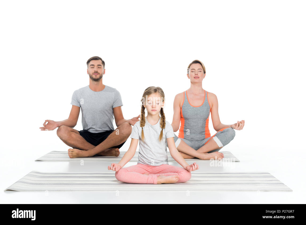 Famiglia di atletica a praticare yoga su stuoie insieme isolato su bianco Foto Stock