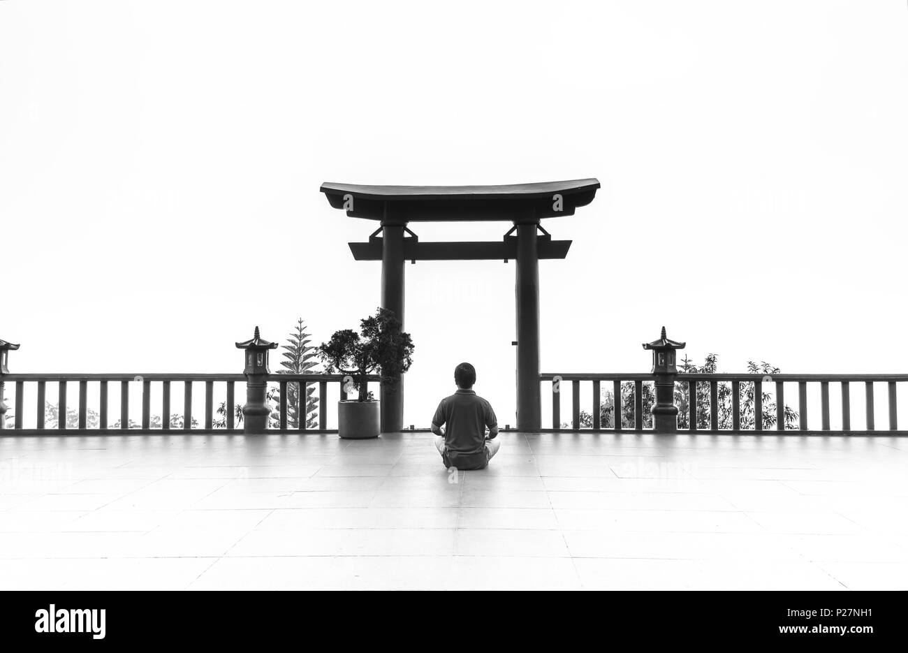 L'uomo meditando davanti il tempio come un modo per rilassarsi anima nel reame spirituale di pace di deposizione in cui Buddha porta in mattinata Foto Stock