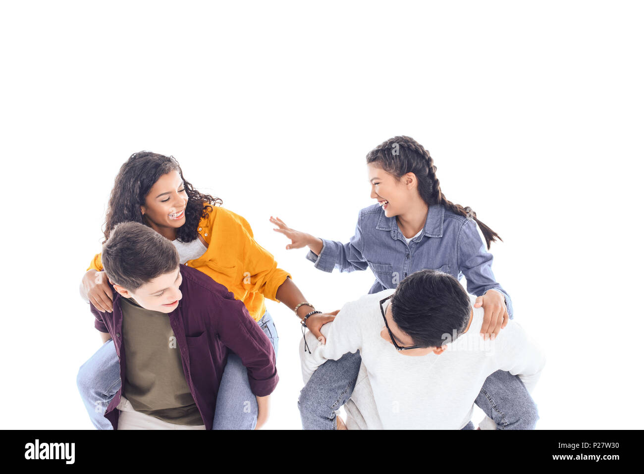 Felice interracial teen amici piggybacking insieme isolato su bianco Foto Stock