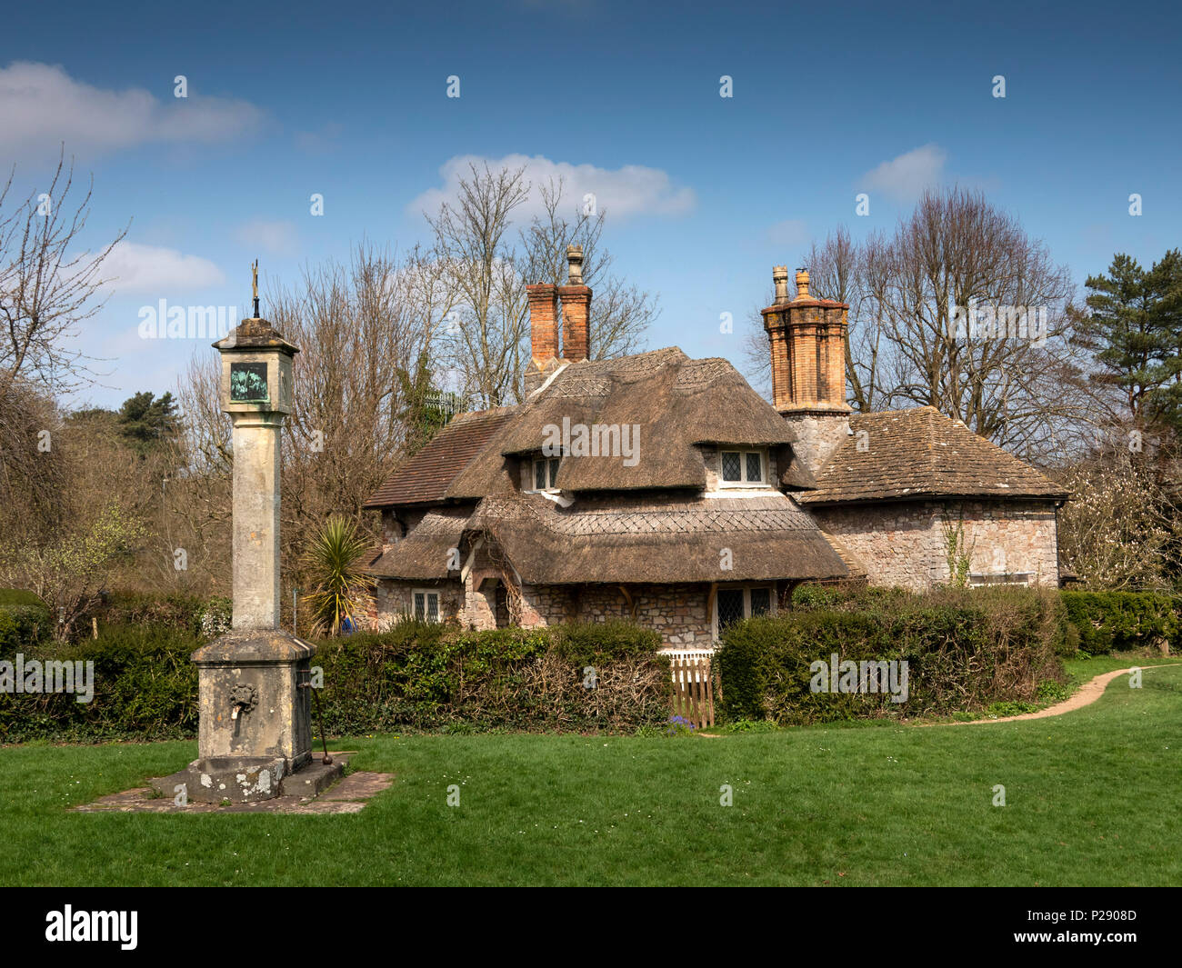 Regno Unito, Inghilterra, Bristol, Henbury, Blaize Borgo Paglia cottage immobiliare intorno al villaggio di pompa acqua su verde Foto Stock