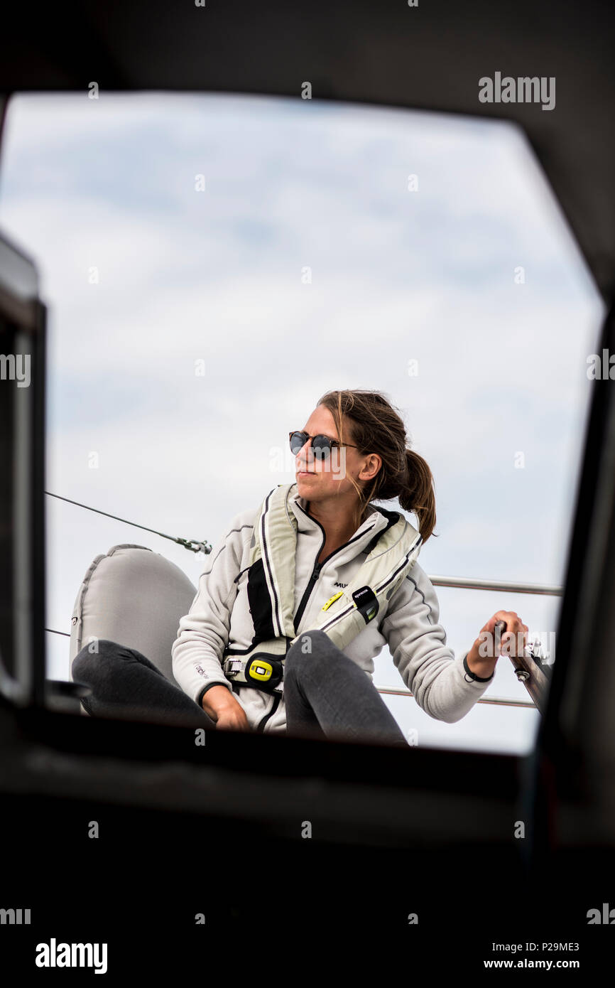 Giovani donna lo sterzo di una barca a vela con il timone. Foto Stock