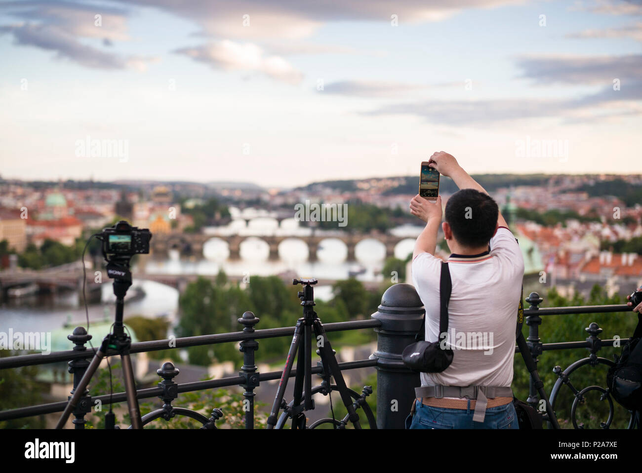 Praga. Repubblica ceca. Tourist utilizzando un telefono cellulare per scattare foto della vista dal parco Letná che fornisce un punto di vista del fiume Moldava e l'O Foto Stock
