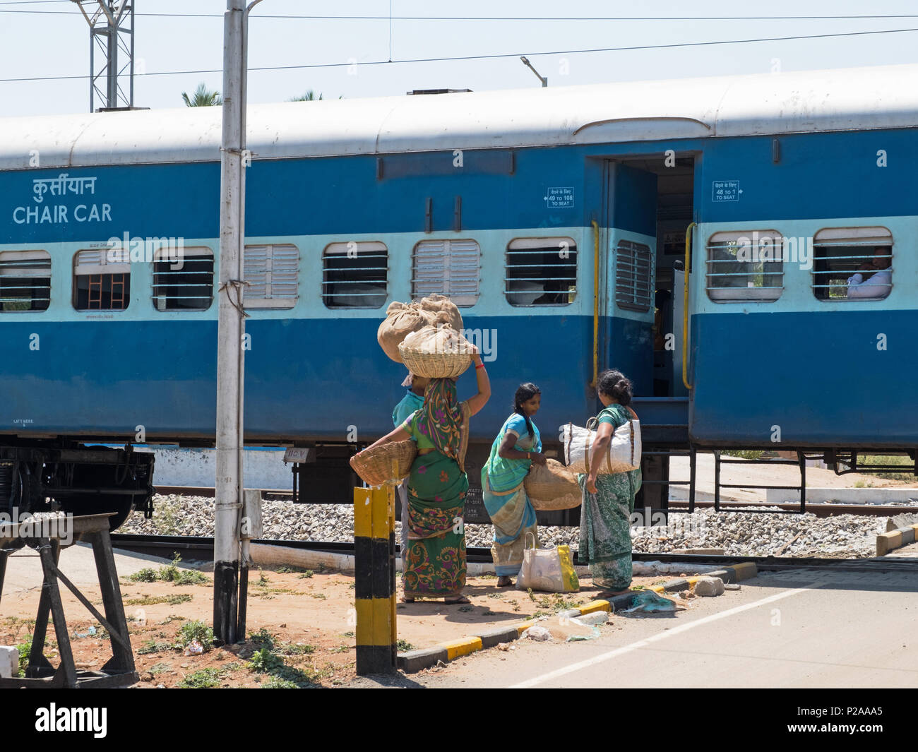 Shrirangapattan, India - 2 Marzo 2018: commercianti ambulanti riuniti su un binario in stazione per la vendita di merce al treno passeggeri Foto Stock