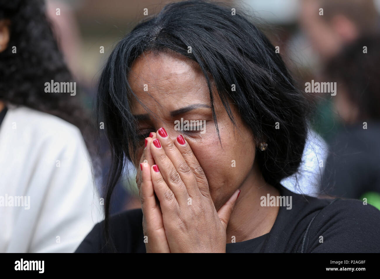 A ovest di Londra. Londra. Regno Unito 14 Giugno 2018 - Membri della famiglia lay ghirlande di fiori e la accensione di candele alla base della torre Grenfell fuori Kensington il centro per il tempo libero. L incendio è scoppiato il 14 giugno 2017 in 24 piani di Grenfell a torre dell'edilizia pubblica appartamenti nel Nord di Kensington, West London, in cui 72 persone hanno perso la loro vita. Credito: Dinendra Haria/Alamy Live News Foto Stock