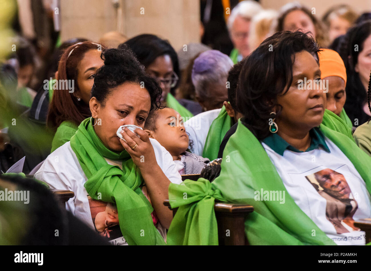 Una donna delle salviette le lacrime mentre frequentano il servizio per contrassegnare il Grenfell Fire anniversario in St Helen's Chiesa, a nord di Kensington, London, England, Regno Unito, 14 giugno 2018 Foto Stock