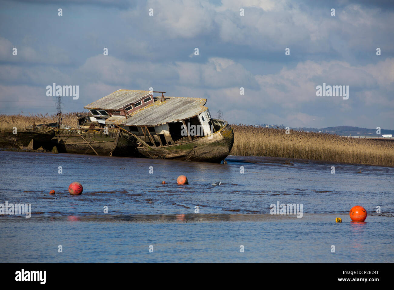 Una casa galleggiante abbandonati e un paio di chiatte marciume sulle velme del Fiume Exe a Topsham, Devon, Inghilterra, Regno Unito Foto Stock