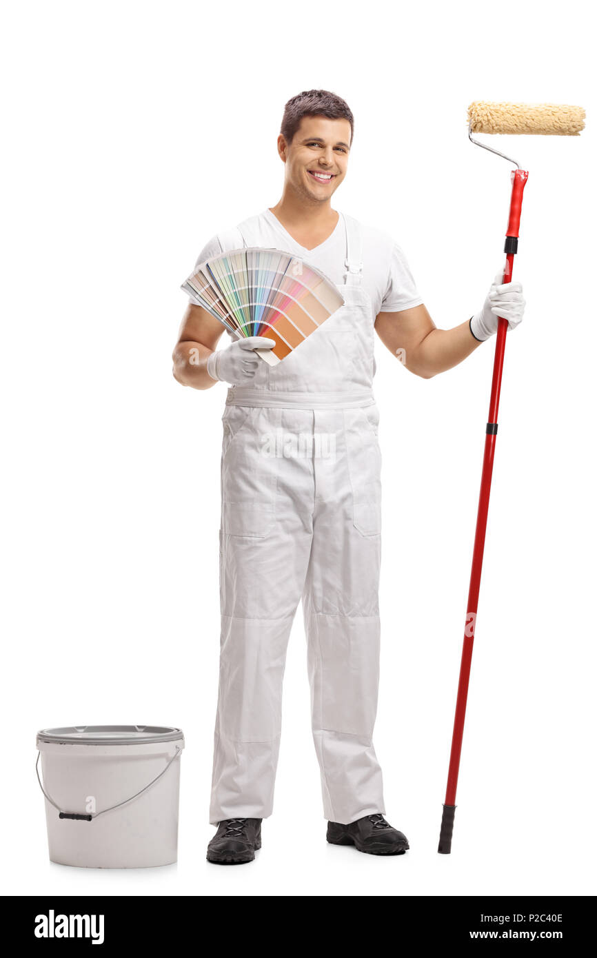 A piena lunghezza Ritratto di un pittore con un campione di colore e un rullo di vernice in piedi accanto ad una benna isolati su sfondo bianco Foto Stock