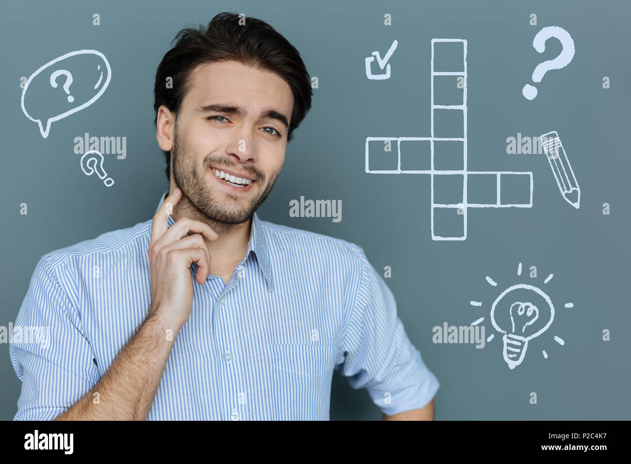 Studente di positivo nel risolvere un puzzle facile e sorridente Foto Stock