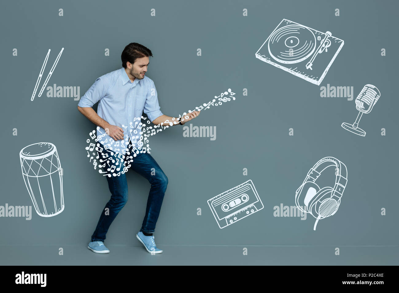 Musicista concentrato a suonare la chitarra mentre è da solo Foto Stock