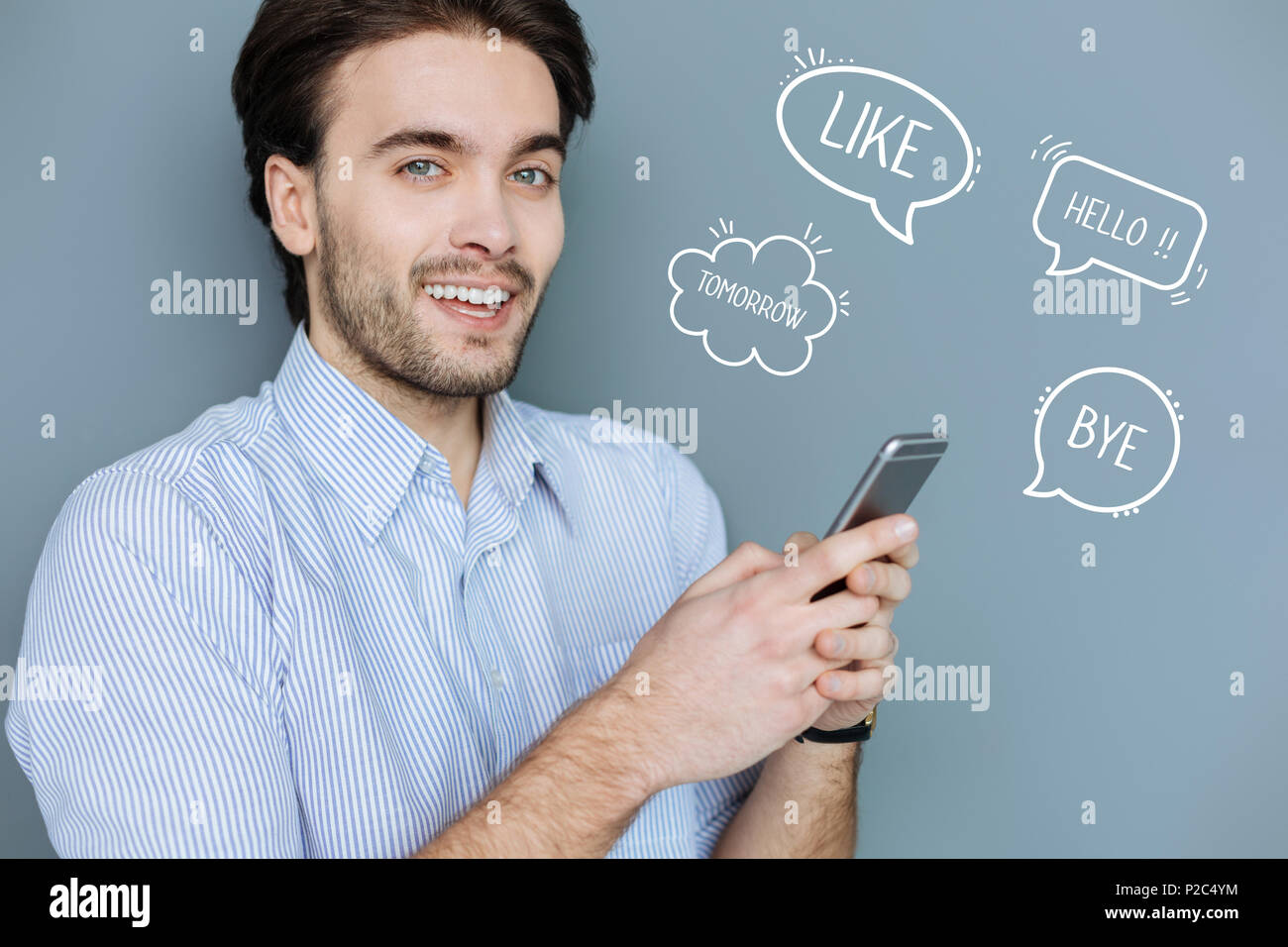 Famoso Internet blogger tenendo un moderno smartphone e guardando fiduciosi Foto Stock