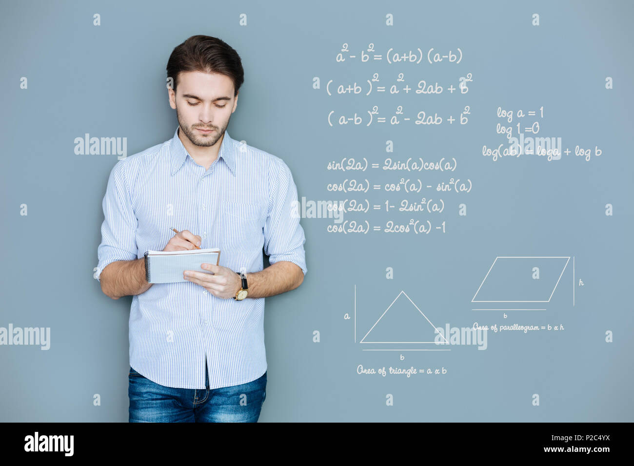 Calma studente rendendo note pur essendo in corrispondenza della lezione di geometria Foto Stock