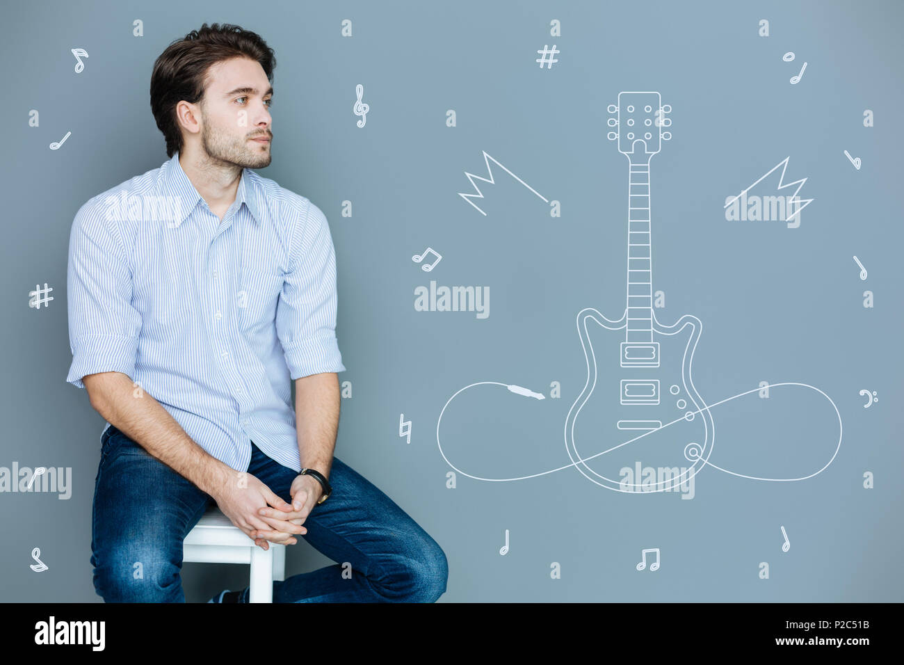 Considerato il musicista seduto da solo e a sognare una nuova chitarra Foto Stock