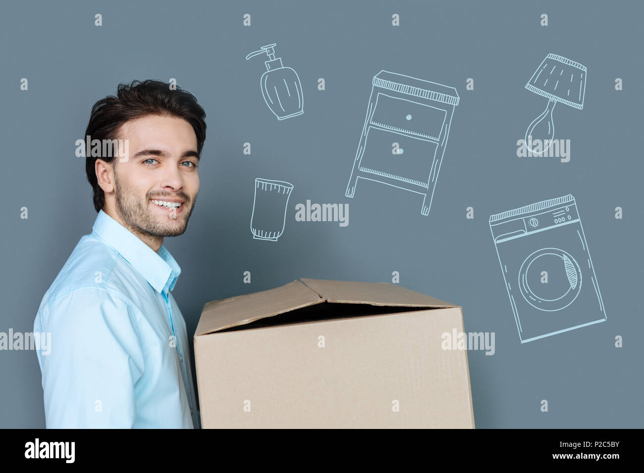 Allegro uomo sentirsi felice mentre si sposta in un nuovo appartamento Foto Stock