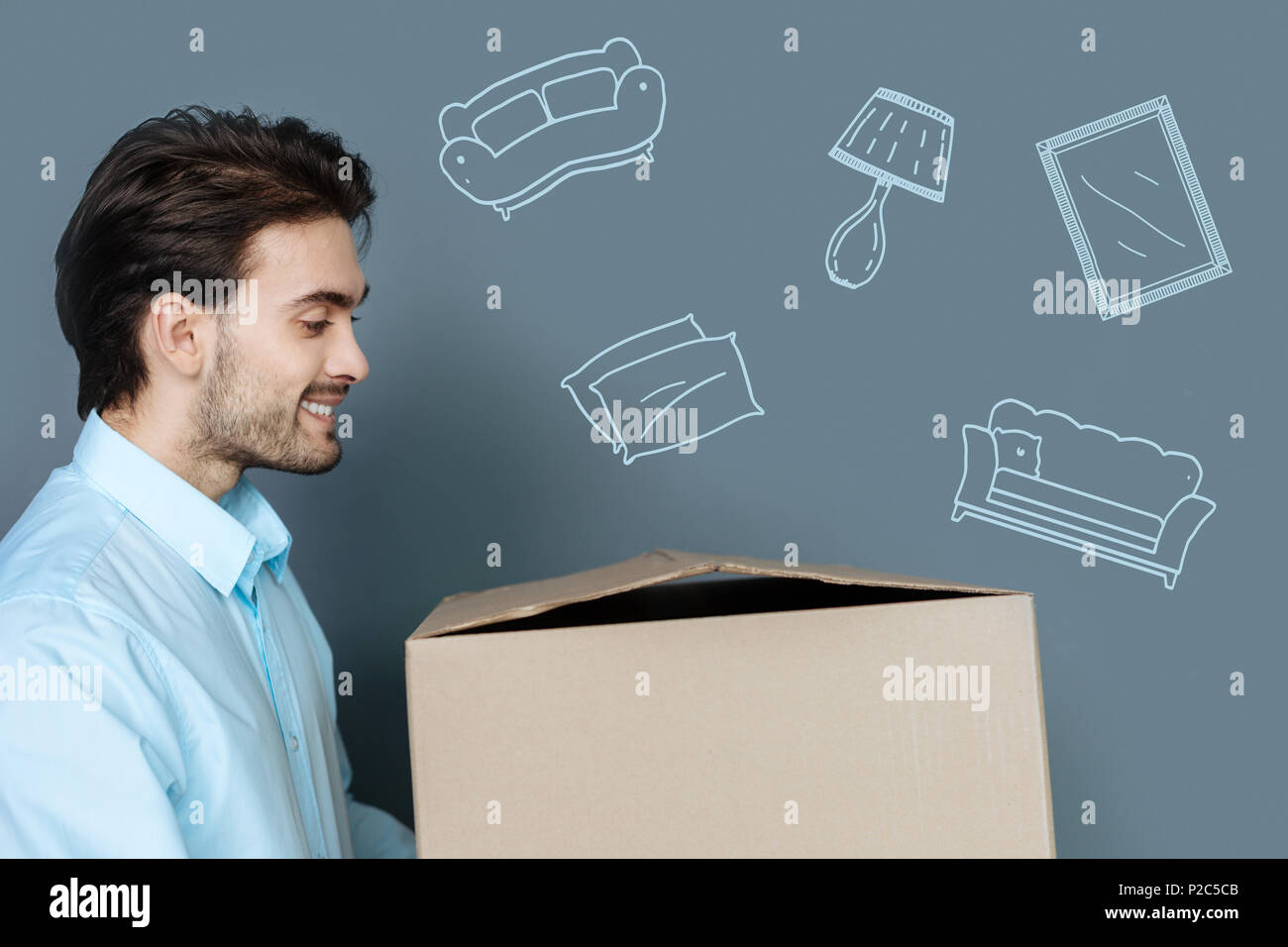 Emotional man looking felici mentre si sposta in un nuovo appartamento Foto Stock