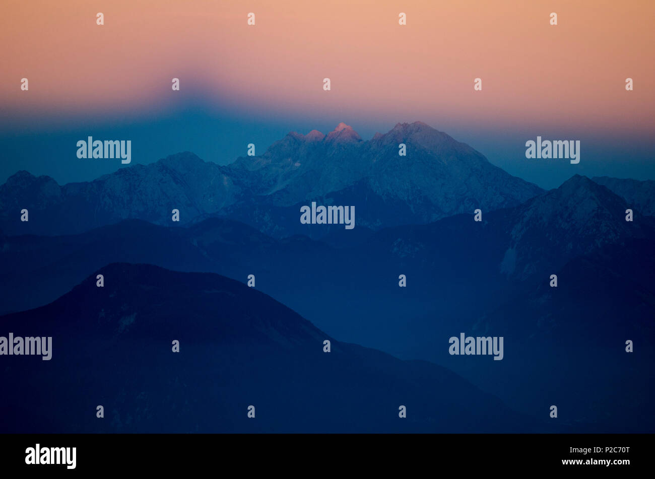 Al tramonto Triglav proietta la sua ombra nel cielo orientale, sulle Alpi Giulie, Slovenia Foto Stock