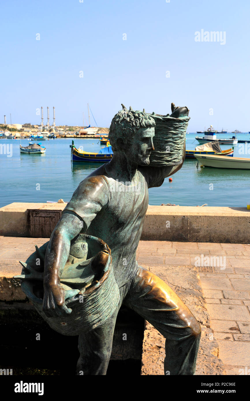 Scultura di pescatori di Marsaxlokk Harbour, costa sud orientale di Malta. Foto Stock