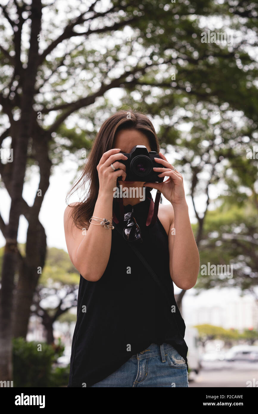 Donna facendo clic su una foto con una fotocamera digitale Foto Stock