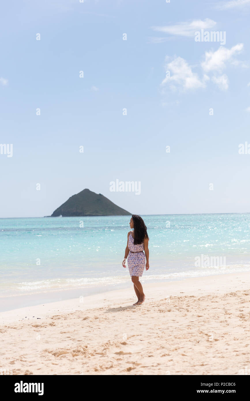 Donna che cammina da sola in spiaggia Foto Stock