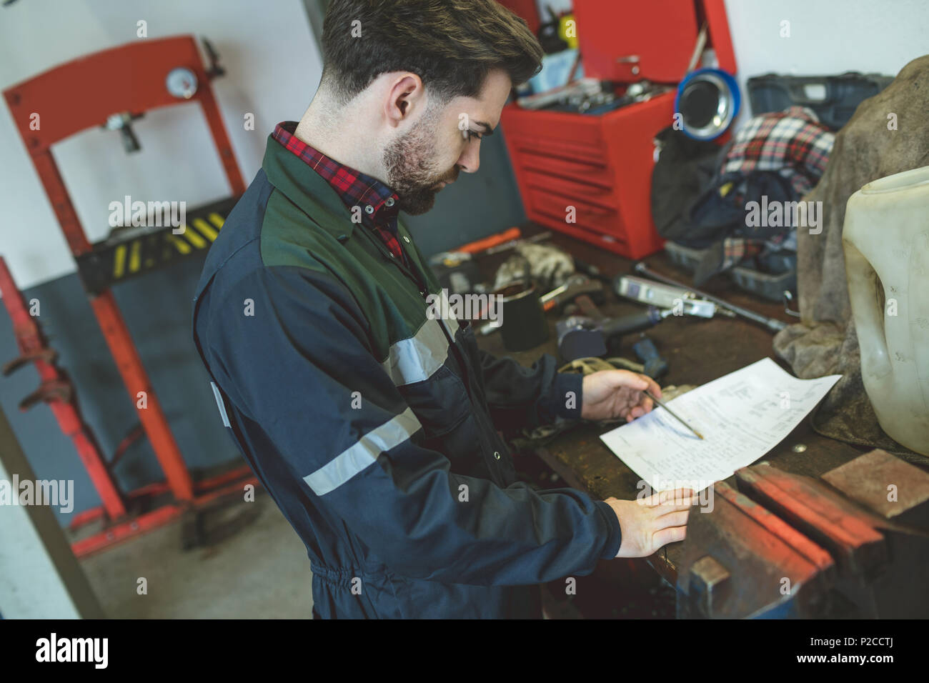 Lettura meccanico manuale di istruzioni nel garage di riparazione Foto Stock