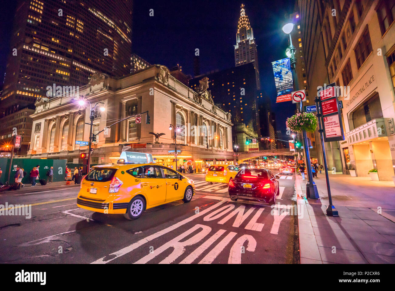 Taxi gialli e macchine che passano dalla Grand Central Terminal verso il Chrysler building su un affollato notte a Manhattan, New York City Foto Stock