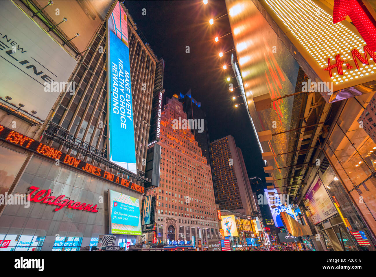 Una vista notturna che conduce in Time Square, Manhattan, New York City con i cartoni animati e colorati di schermi pubblicitari, attirare folle a vista. Foto Stock