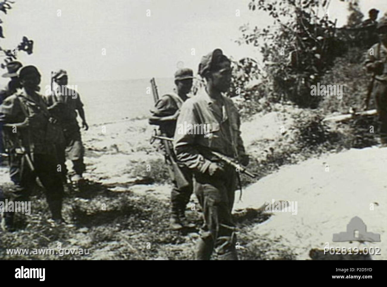 . Inglese: AWM didascalia: Tarakan, Borneo. 1945. Lo sbarco su una sezione distributore di Tarakan della costa, una delle numerose pattuglie indonesiano prepara a reconnoitre entroterra per cancellare il vicino paese di lottatori giapponesi. Questo patrol è parte del primo combinato di AIF e Royal Netherlands Indies Forze armate attacco contro i Paesi Bassi indie. 1945. Paesi Bassi Indie Servizio informazioni di stato 61 Tarakan patrol (p02819-002) Foto Stock