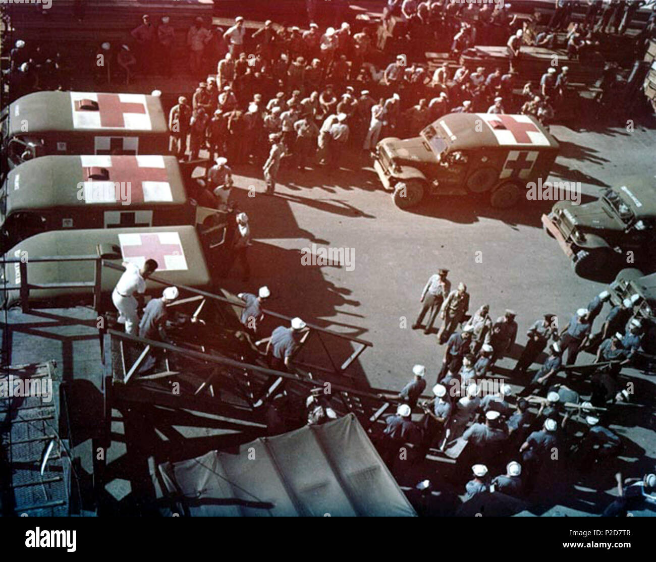 . Superstiti dell'incrociatore pesante USS Indianapolis (CA-35) sono portati a terra da parte degli Stati Uniti Navy nave ospedale USS tranquillità (AH-14) a Guam, 8 agosto 1945. Essi vengono posti in ambulanza per il trasferimento immediato per ospedali locali. 8 agosto 1945. Fotografata da PhoM1c J.G. Mull, USN 4 ambulanze sul molo di Guam per i superstiti della USS Inianapolis (CA-35) nel mese di agosto 1945 Foto Stock