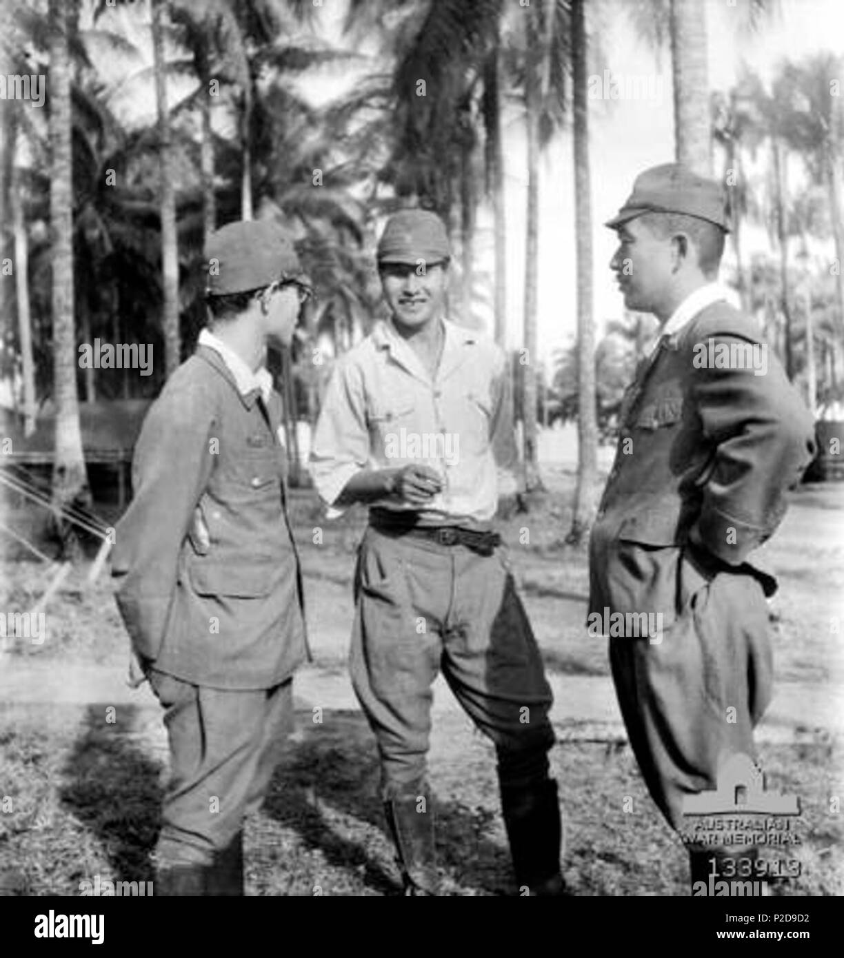 . Inglese: LABUAN, BORNEO. 1946-01. Capitano SUSIMI HOSHIJIMA (centro), giapponese Comandante del campo di prigionia di Sandakan, BORNEO, che è sul banco di prova come un criminale di guerra presso la sede 9° Divisione. Egli sta parlando con il suo avvocato della difesa al di fuori della stanza della guerra in cui il processo si svolge. Gennaio 1946. non specificato 11 Capitano Susumi Hoshijima AWM-133913 Foto Stock