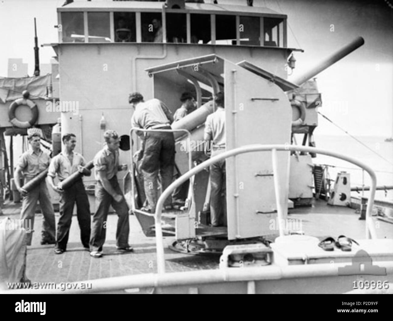 . AWM caption : 'TARAKAN isola. 1945-06-22. HMAS COWRA e equipaggio, precedentemente innestata in MINESWEEPING CONVOGLIO E LAVORO TARAKAN Round Island, ha iniziato i preparativi per un viaggio a MOROTAI. Mostrato, i membri dell equipaggio praticanti trapano a pistola sulla nave di armamento principale, un 4 pollici M19 Pistola QF. Il personale identificato sono:- PM4633 in grado marinaio C. D. SENTITO (1); 21756 PETTY OFFICER J. L. grigio (2); B2344 in grado marinaio H. W. MOESSINGER (3); PM2160 marinaio leader N. R. GERRARD (4); PM3489 in grado marinaio E. A. Thompson (5); PM6741 in grado marinaio N. B. Pastore (6); PA4352 in grado marinaio I. S. fumatore (7).' . Il 22 giugno 1945. Non recor Foto Stock
