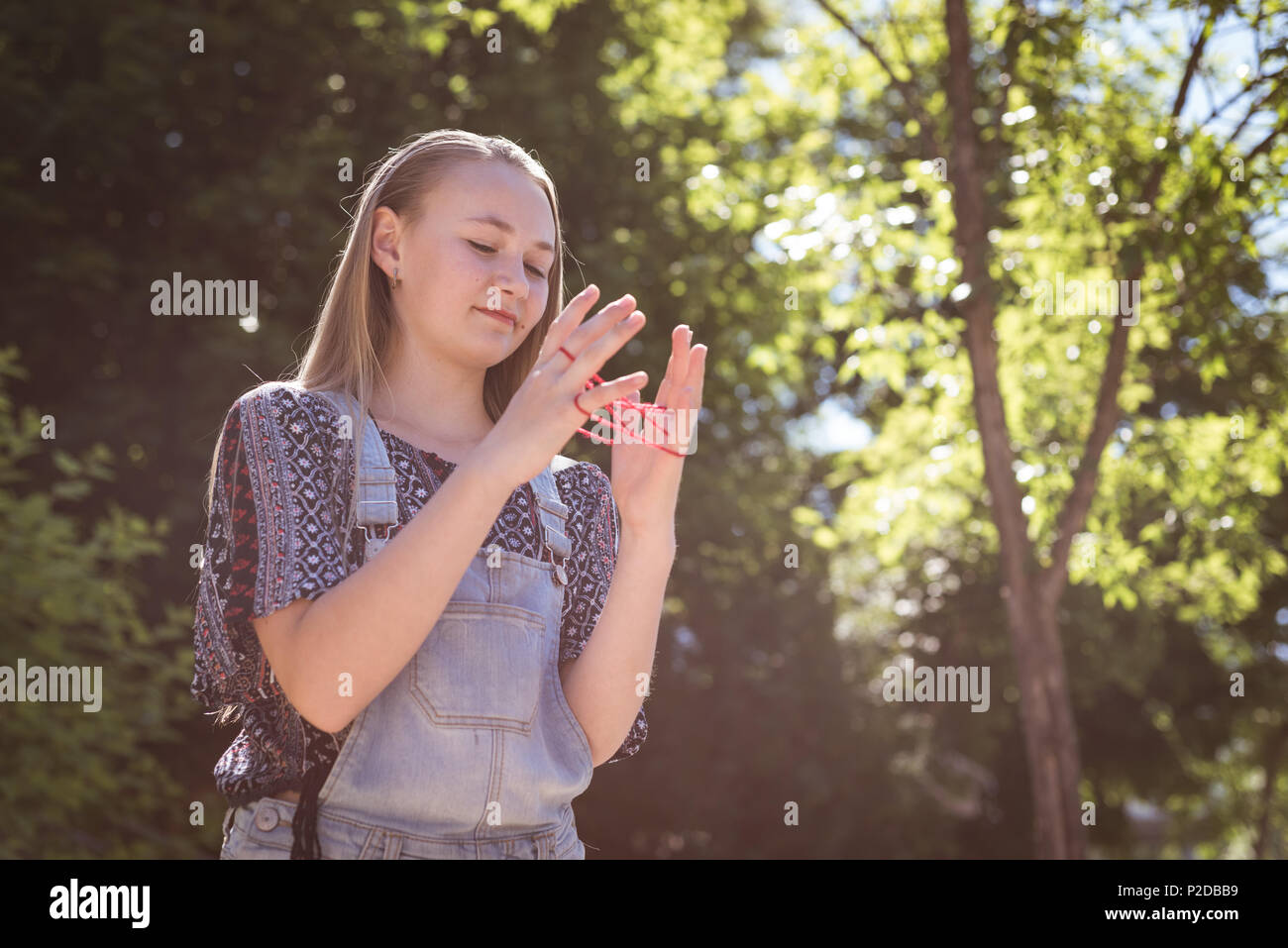 Ragazza che gioca il gioco di stringa con fascia di gomma Foto Stock