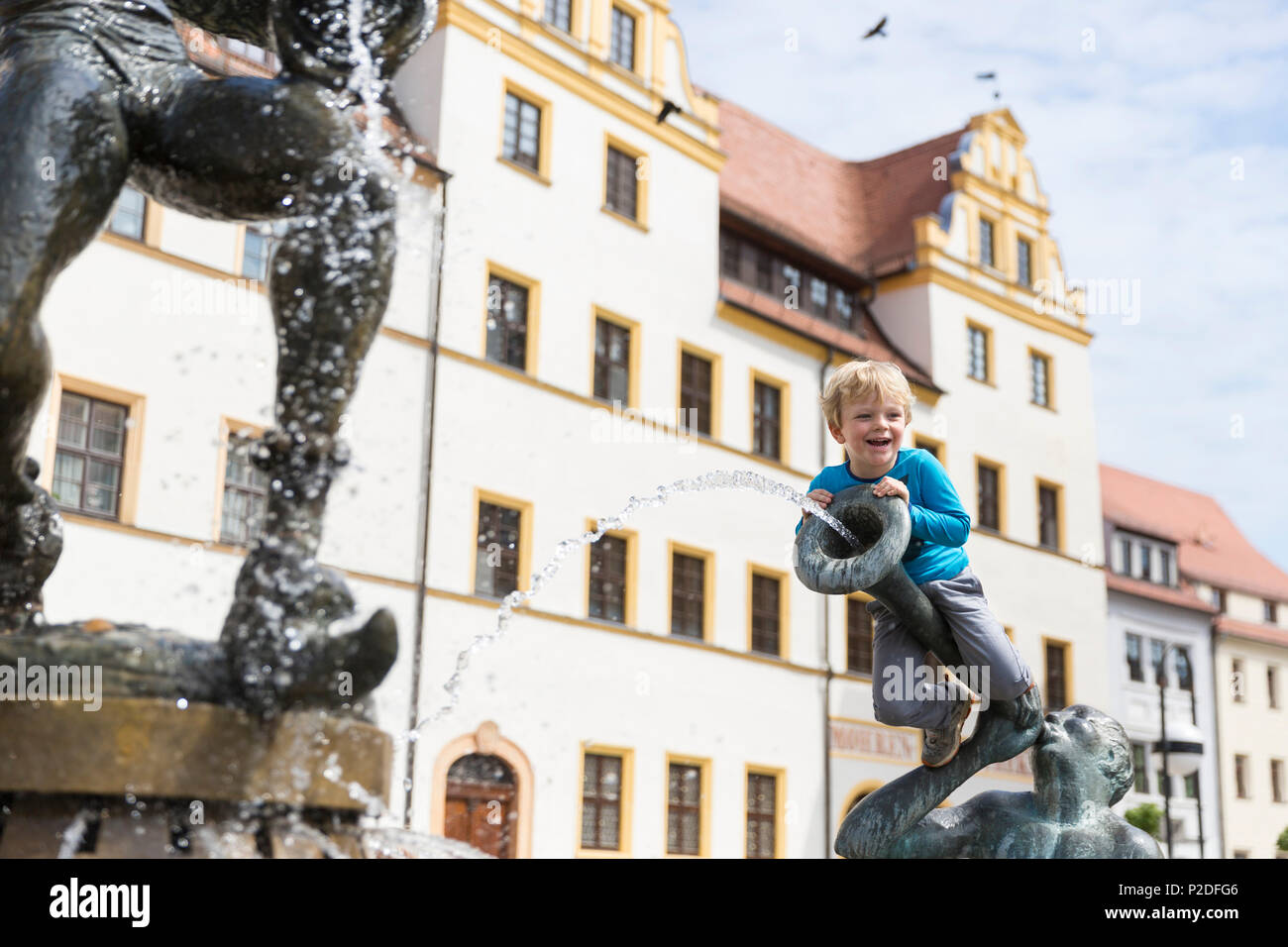 Ragazzo seduto sulla fontana al di fuori del municipio, Torgau, in Sassonia, Germania, Europa Foto Stock