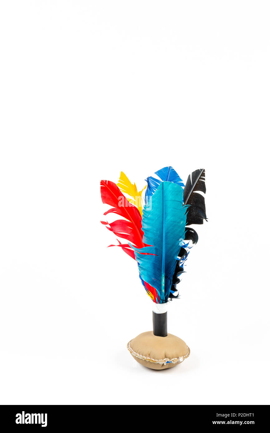 Close up artigianale di volano giocattolo con piume colorate su sfondo bianco. Foto Stock