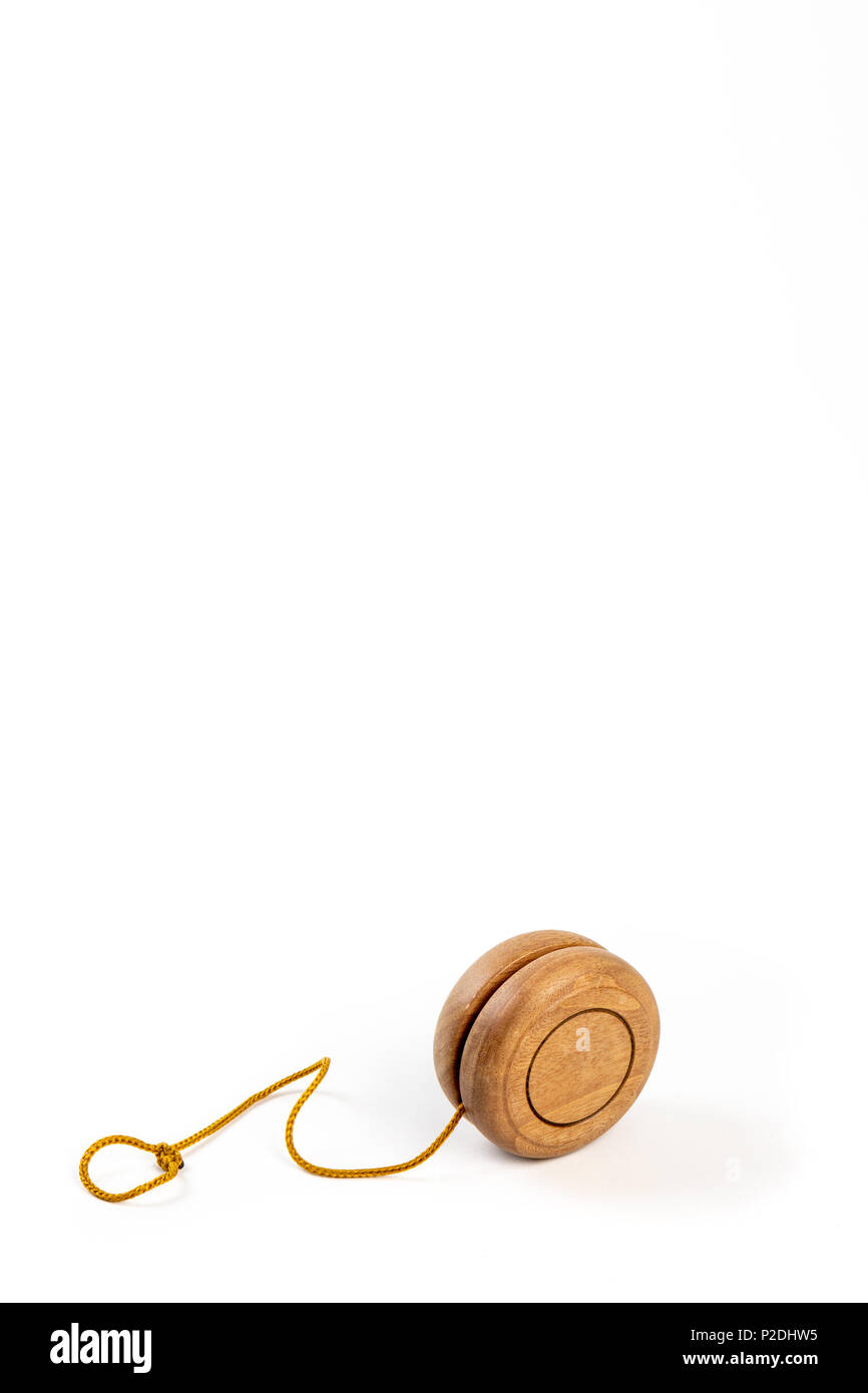 Close up di un di legno yo-yo con la stringa di colore giallo su sfondo bianco. Foto Stock