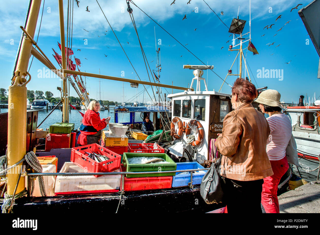 Donna di vendita del pesce da una barca, Travemuende, città anseatica di Lubecca, costa baltica, Schleswig-Holstein, Germania Foto Stock
