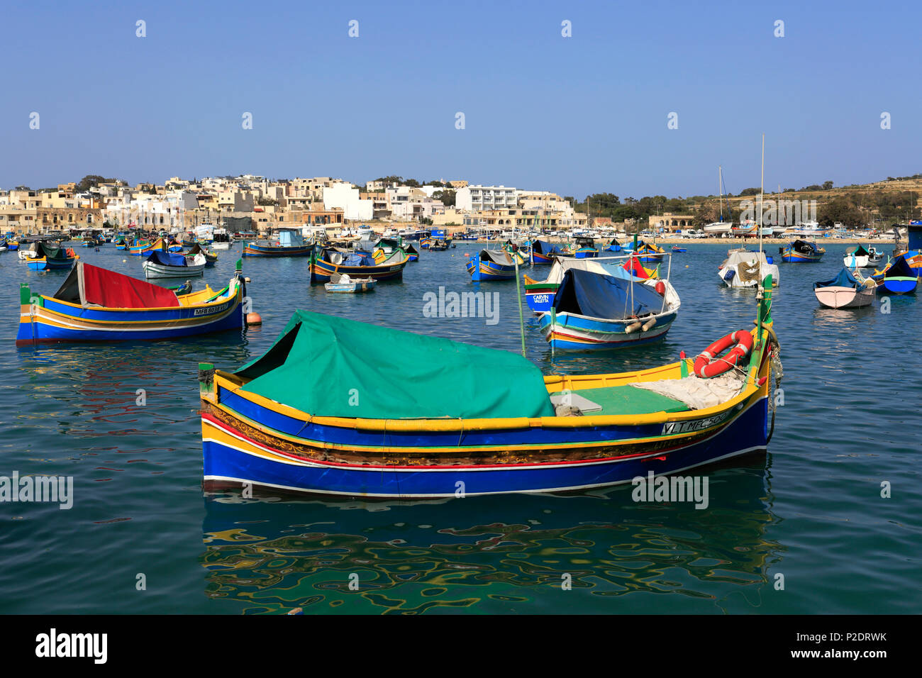 Vivacemente colorato Luzzu barche nel porto di Marsaxlokk, costa sud orientale di Malta. Foto Stock