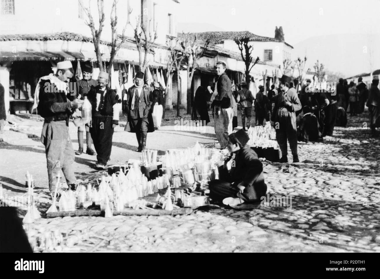 . Deutsch: Bazar im Zentrum von Tirana. Der Händler verkauf Blechgeschirr wie Trichter und Töpfe. 1923. Frank e Francesca falegname. 63 Tirana Bazar Foto Stock