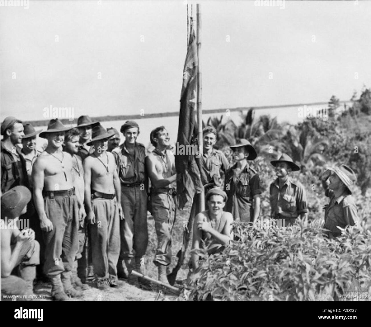 . Inglese: soldati australiano di innalzare la bandiera australiana su un palo di bambù a Lingkas, Tarakan il primo giorno di funzionamento Oboe uno, la IX Divisione di attacco con successo e lo sbarco sul Tarakan isola. 1 maggio 1945. US Navy 5 bandiera australiana Lingkas Tarakan Foto Stock