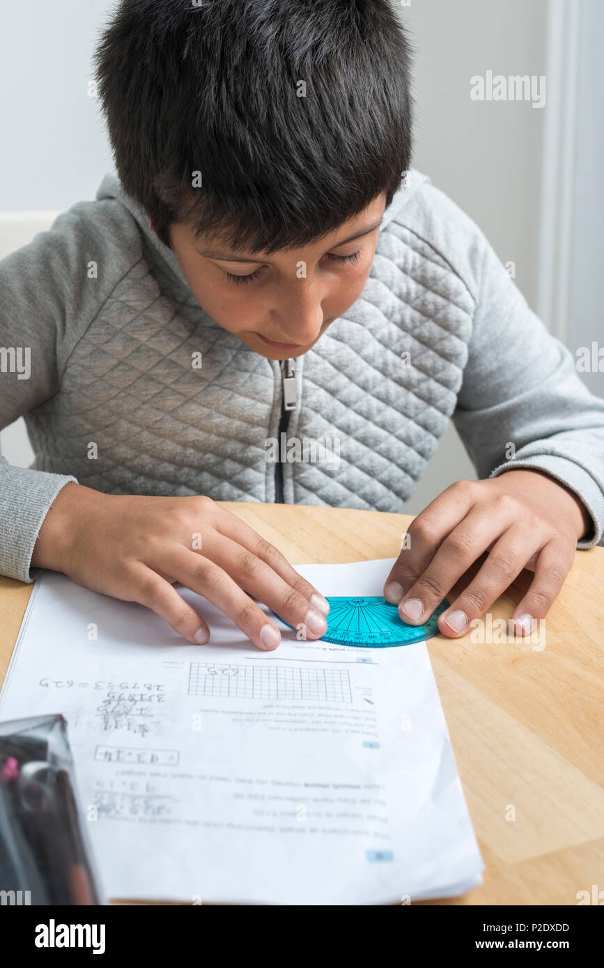 Bambino lavorando sulla matematica compiti-usando il goniometro,fuoco selettivo Foto Stock