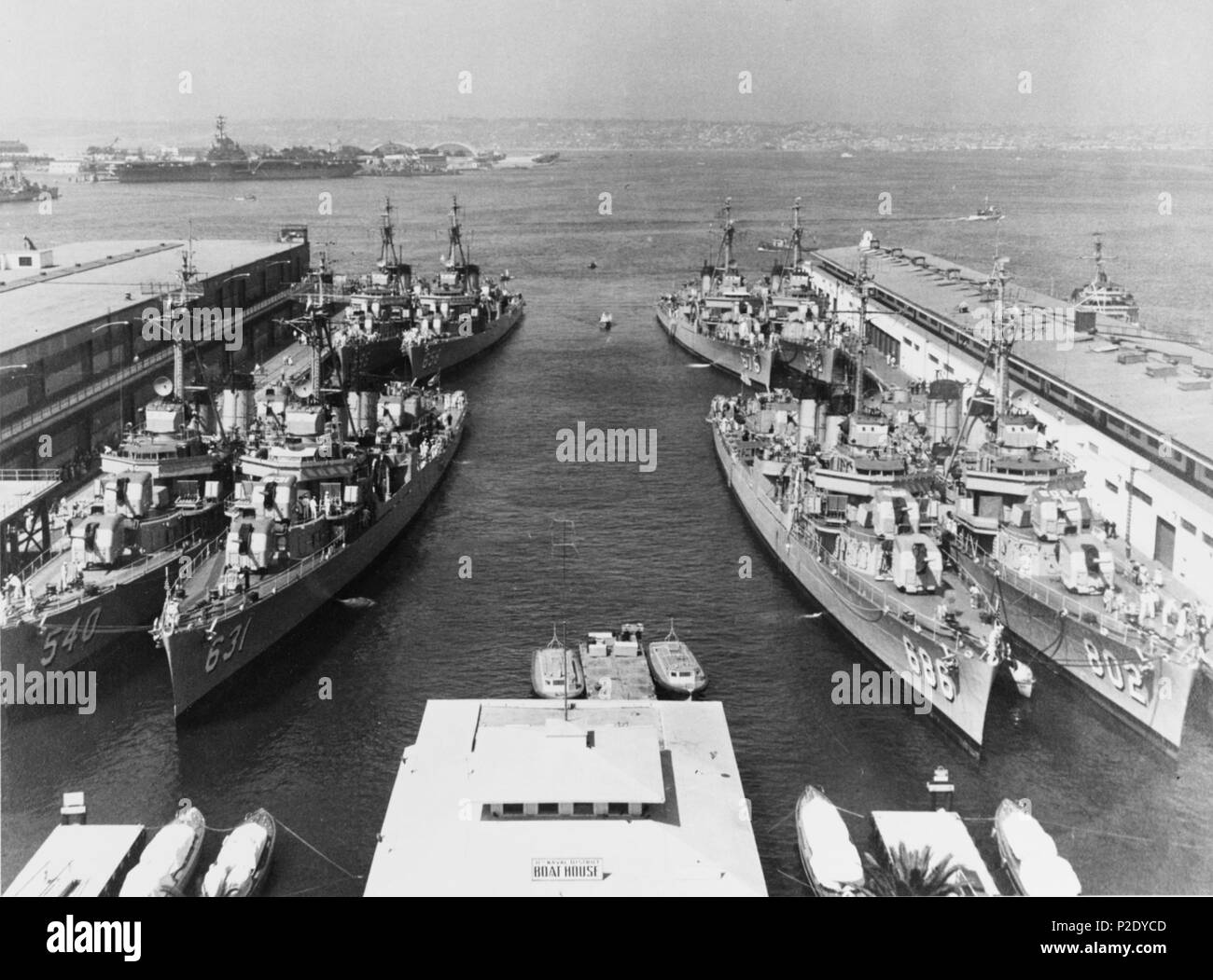. Gli Stati Uniti Navy Destroyer Squadron 17 fotografata al piede di Broadway, San Diego, California (USA), nel marzo 1955. Cacciatorpediniere nella fila anteriore comprendono (da sinistra a destra): USS Twining (DD-540); USS Erben (DD-631); USS Halsey Powell (DD-686) e USS Gregorio (DD-802). Dietro di loro sono (da sinistra a destra): USS scudi (DD-596); USS Colahan (DD-658); USS Marshall (DD-676) e USS Porterfield (DD-682). La portaerei USS Kearsarge (CVA-33) è legato in alto a sinistra la distanza, alla Naval Air Station, Isola del nord. La struttura nel centro di fondo è il "Destroyer navale Boat House". Marzo 1955. USN 15 DES Foto Stock