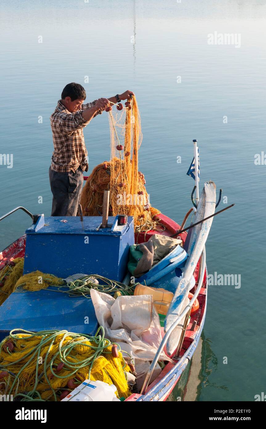 Grecia CICLADI, isola di Paros, Naoussa, pescatore e le sue reti nel porto Foto Stock