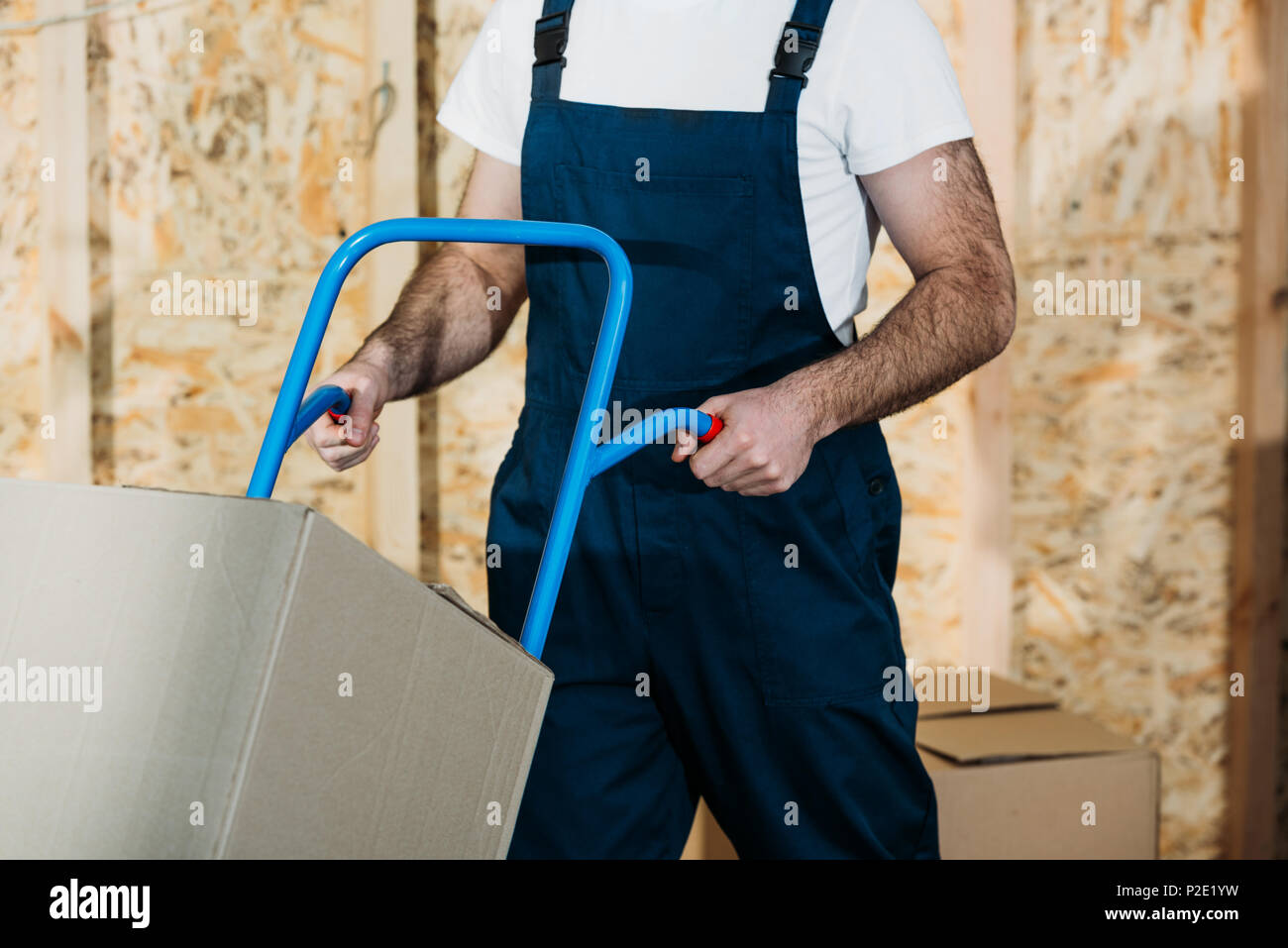 Uomo di consegna spingendo il carrello con scatole Foto Stock