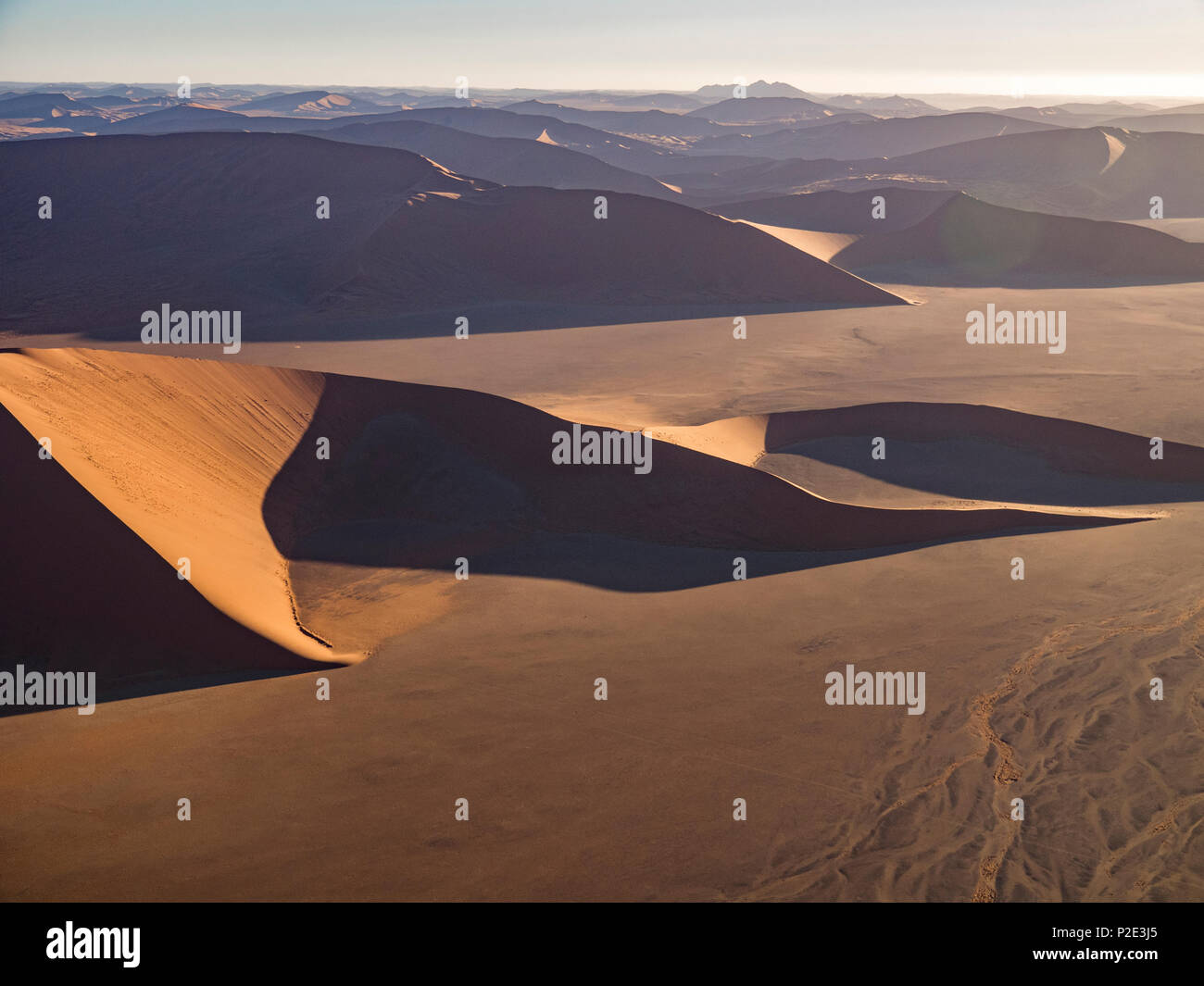 Dune rosse che salgono dal pavimento del deserto Foto Stock